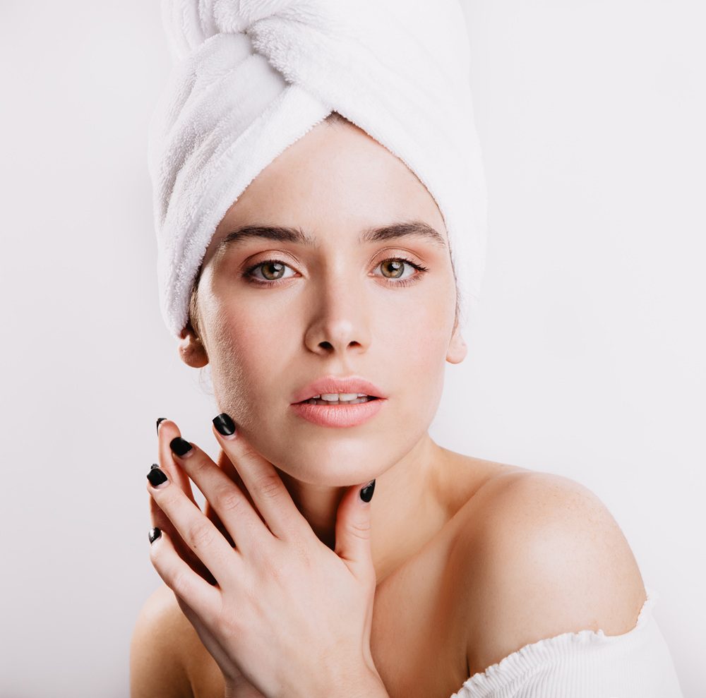 Closeup portrait of calm woman in towel after shower. Lady with green eyes and no makeup looking into camera. Closeup portrait of calm woman in towel after shower. Lady with green eyes and no makeup looking into camera.